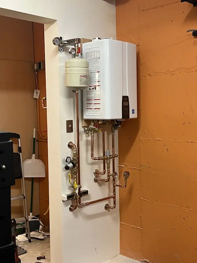 Plumbing technician inspecting water heater connections in Haltom City